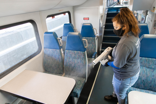 Metrolink employee using cleaning machine on train to sanitize and disinfect