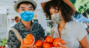 A couple wearing masks at a farmers market